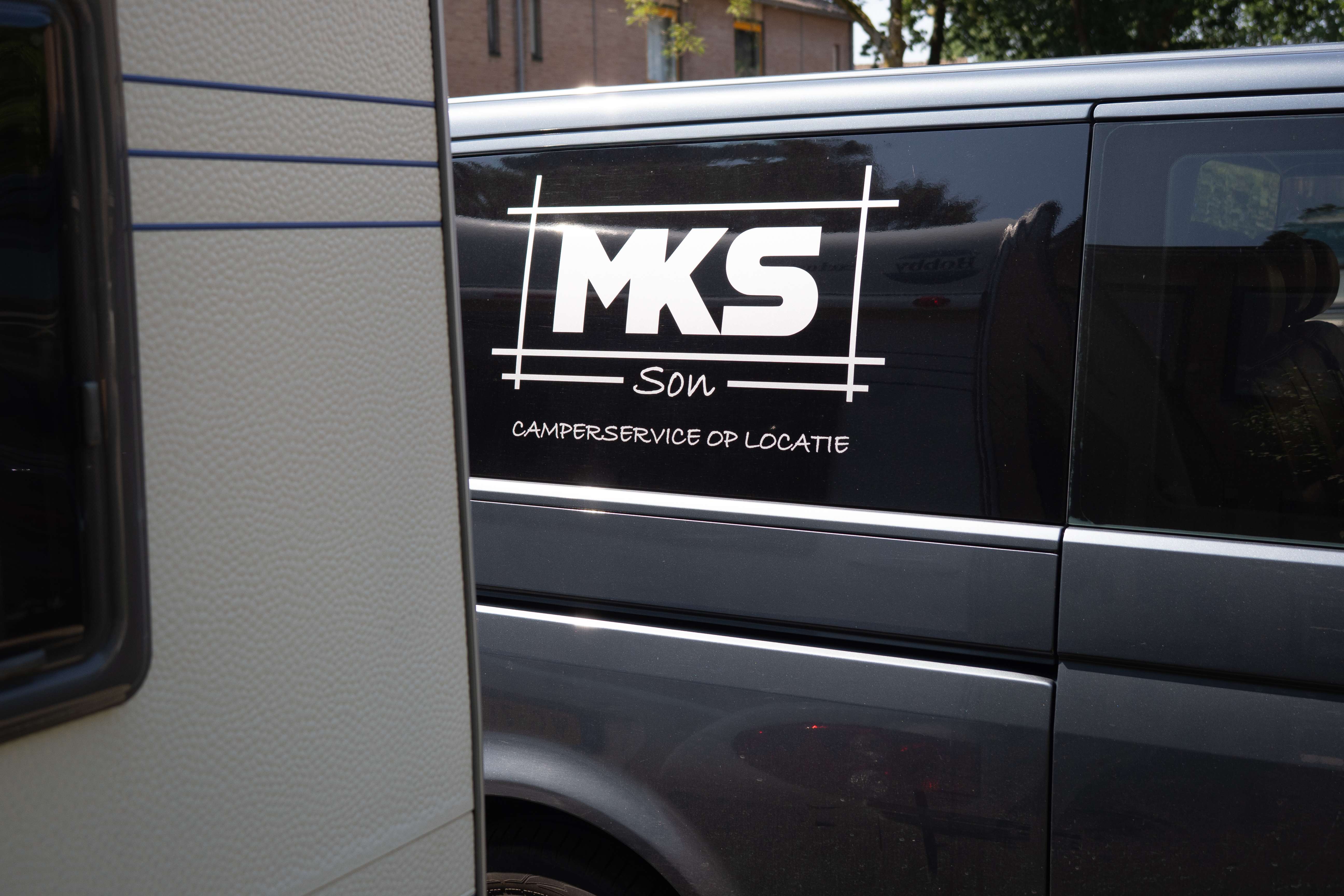 De MKS Son bedrijfsbus met logo — camperservice op locatie